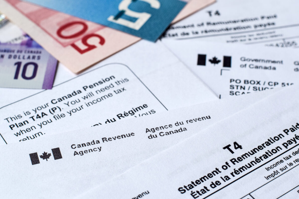 des documents fiscaux du gouvernement étalés sur un bureau avec des billets de 50 dollars