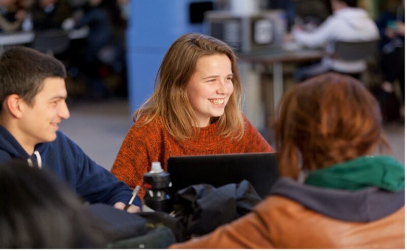 Des étudiants souriants assis à une table