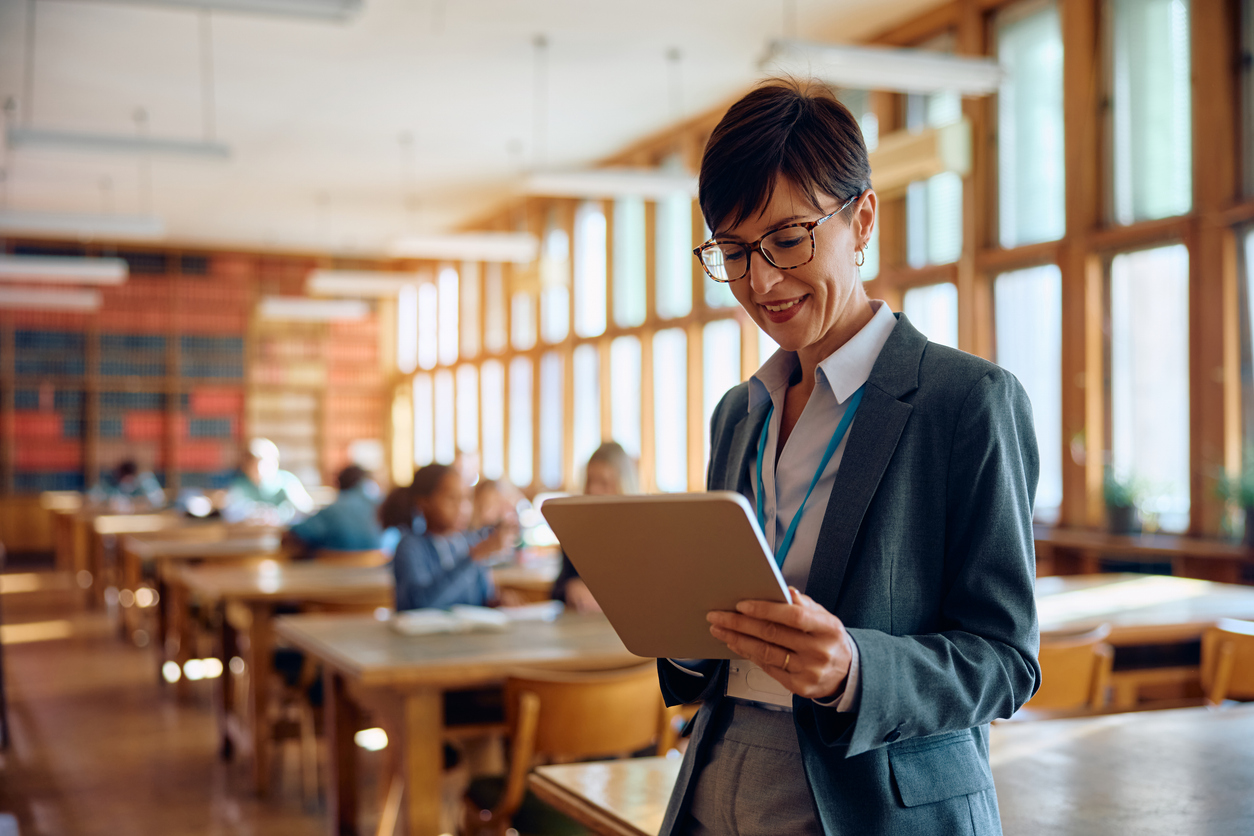 Professionnelle heureuse utilisant un pavé tactile dans une salle de classe